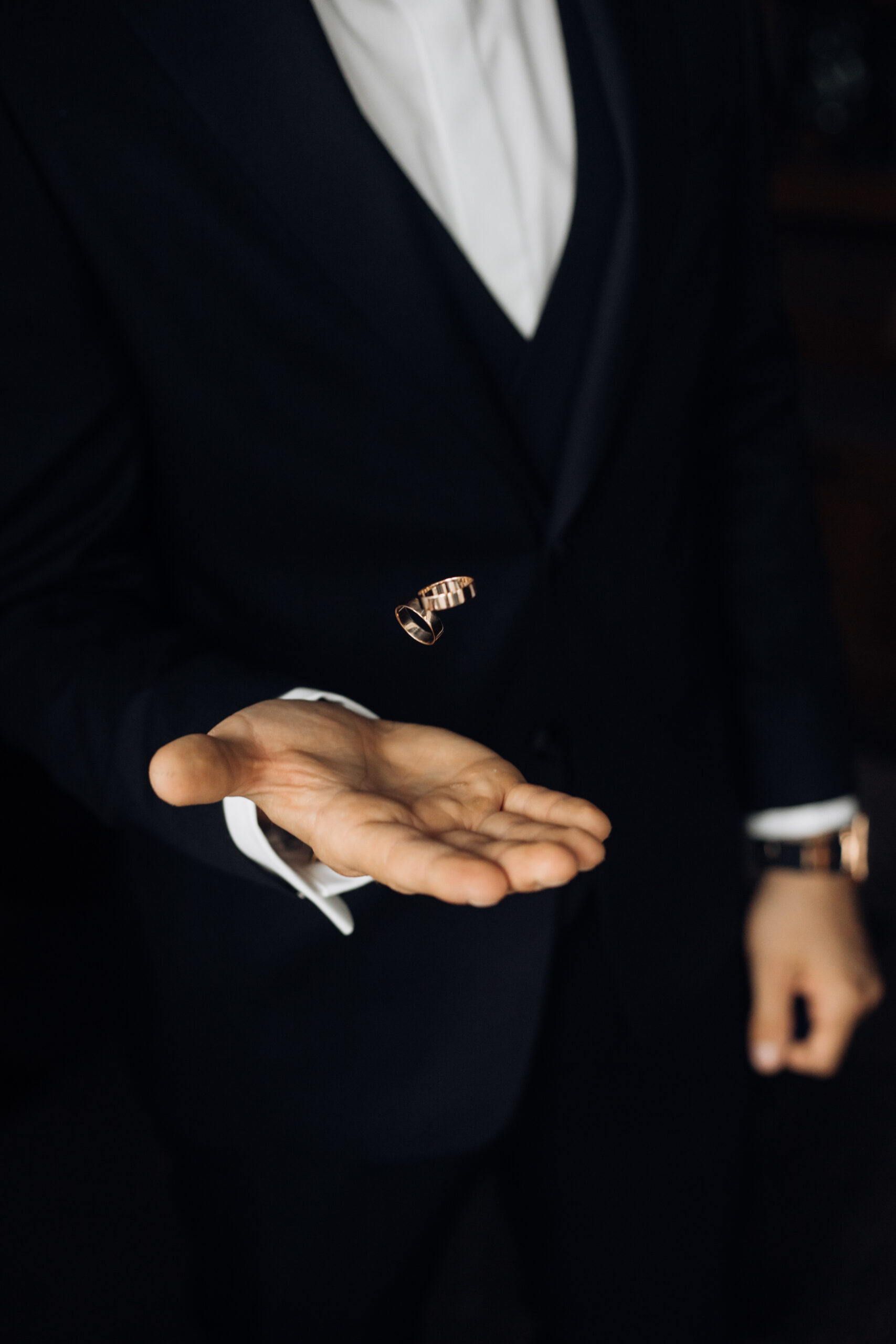 man in the black suit is tossing two wedding rings man in the black suit is tossing two wedding rings